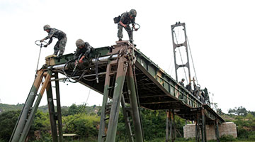 Soldiers assemble trailer-launched bridge