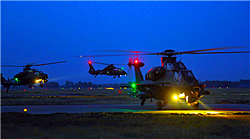 Helicopters lift off at night