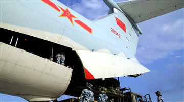 Airmen load cargo into transport aircraft
