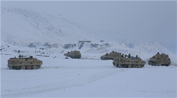 Armored vehicles rumble on snow-covered road