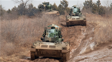 Armored vehicles maneuver on rugged mountain road