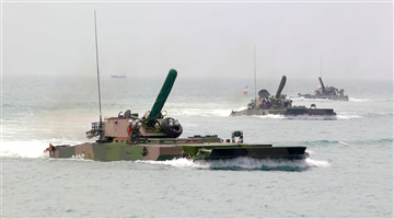 Amphibious armored vehicles move forward at sea