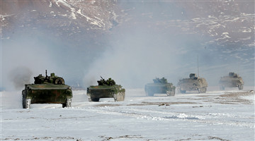 Armored vehicles rumble in snow-covered valley