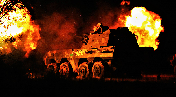 Armored vehicle blasts main gun at night