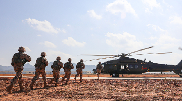 Soldiers rush to board helicopter during air-ground exercise